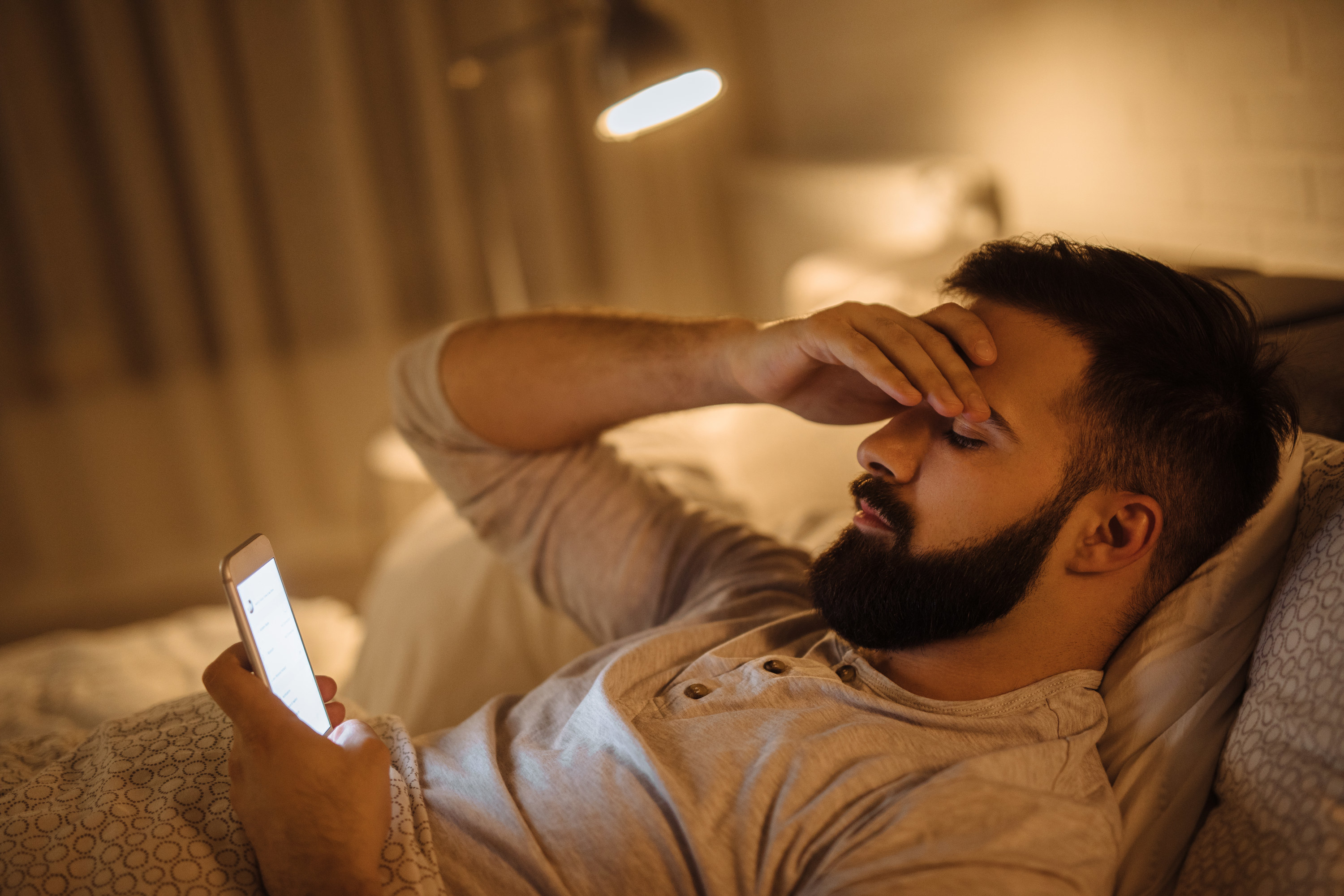 Worried young man reading bad news on smart phone