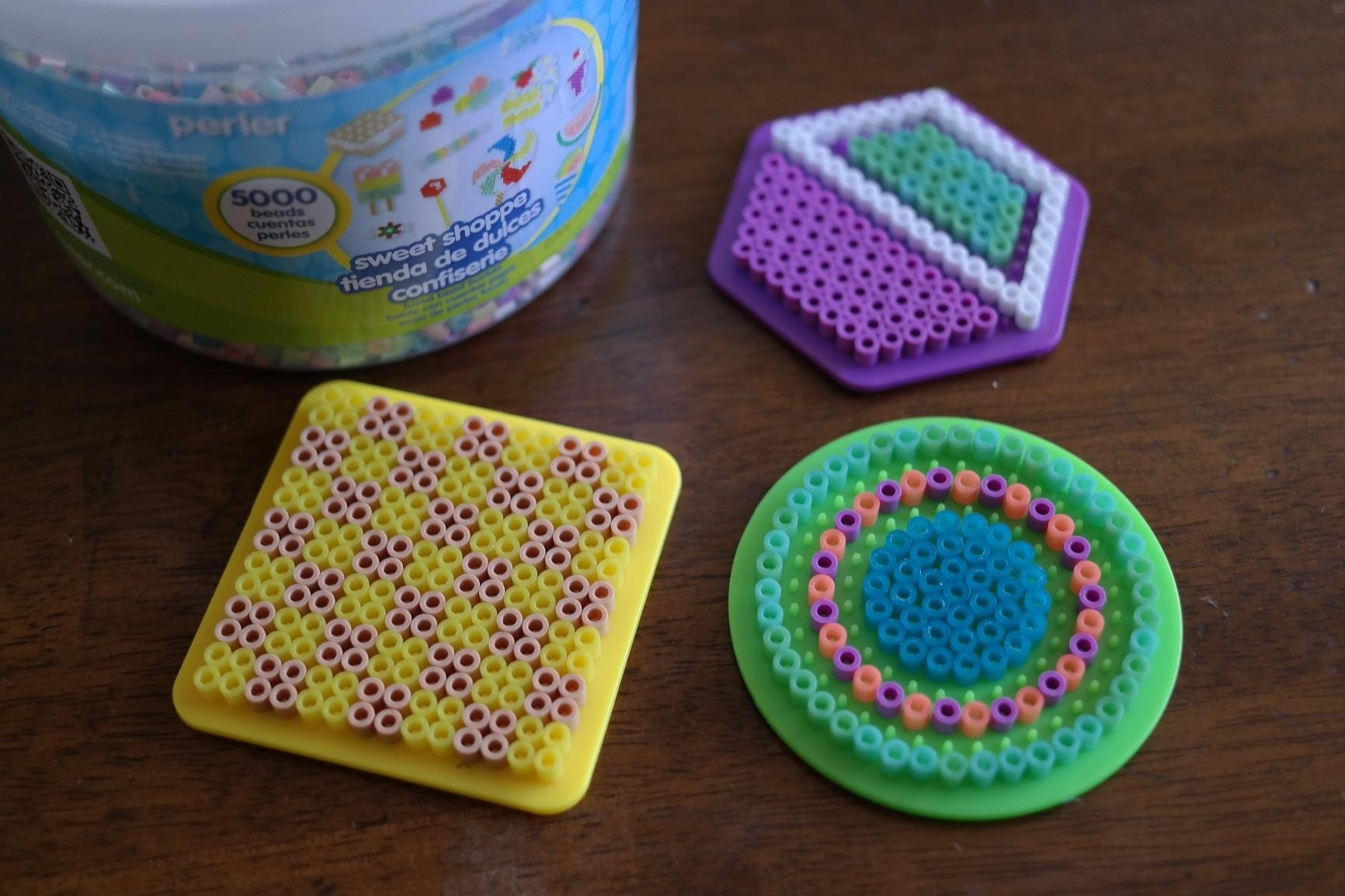 a reviewer photo of the bucket of perler beads and the peg boards