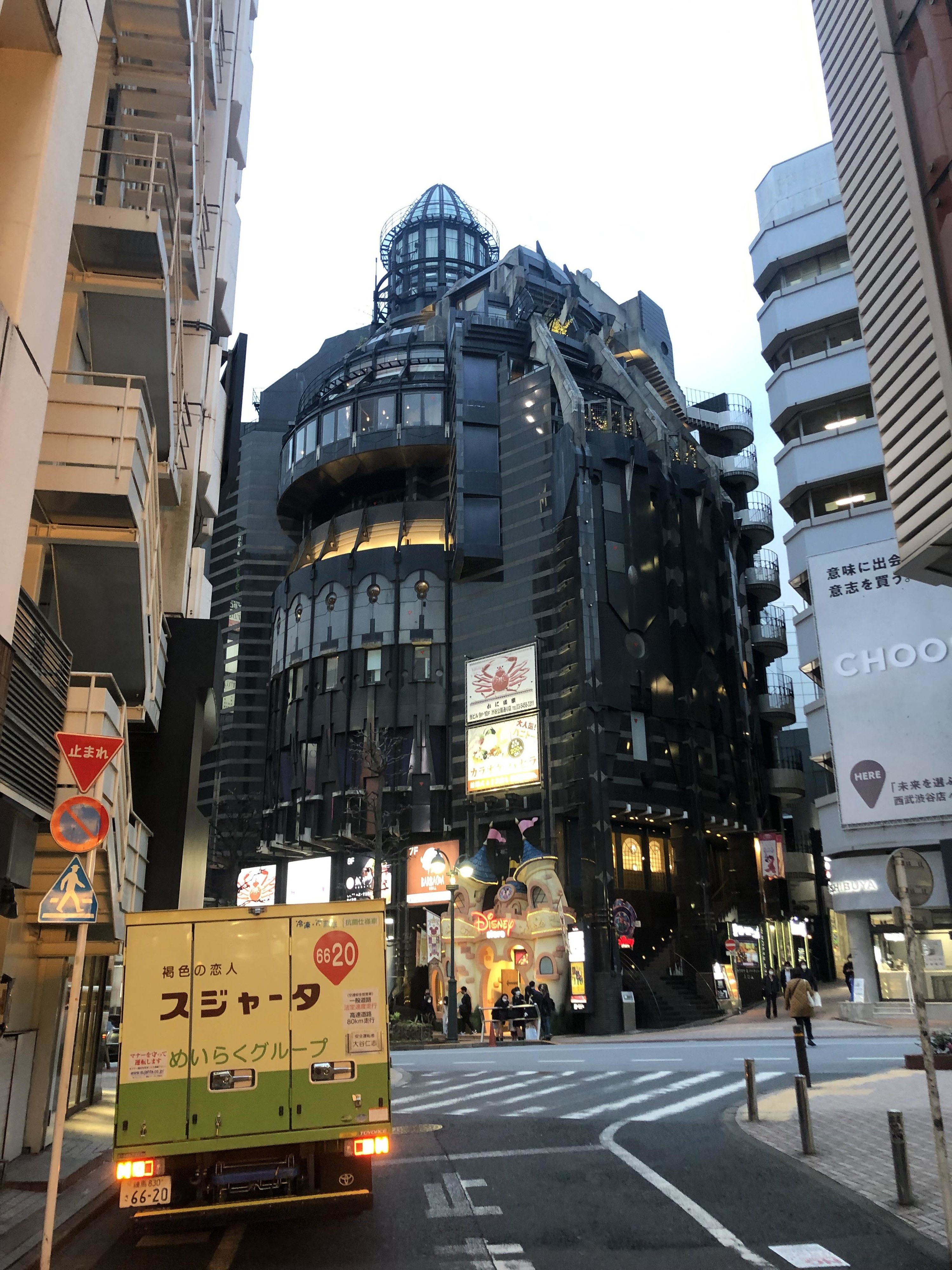 a building in the center of a city that&#x27;s all blak, and has gothic sharp edges