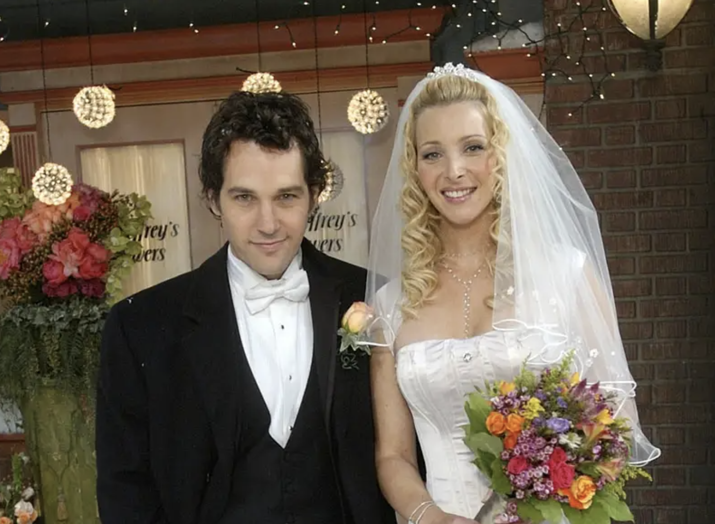 paul rudd and lisa kudrow stand next to each other in wedding attire