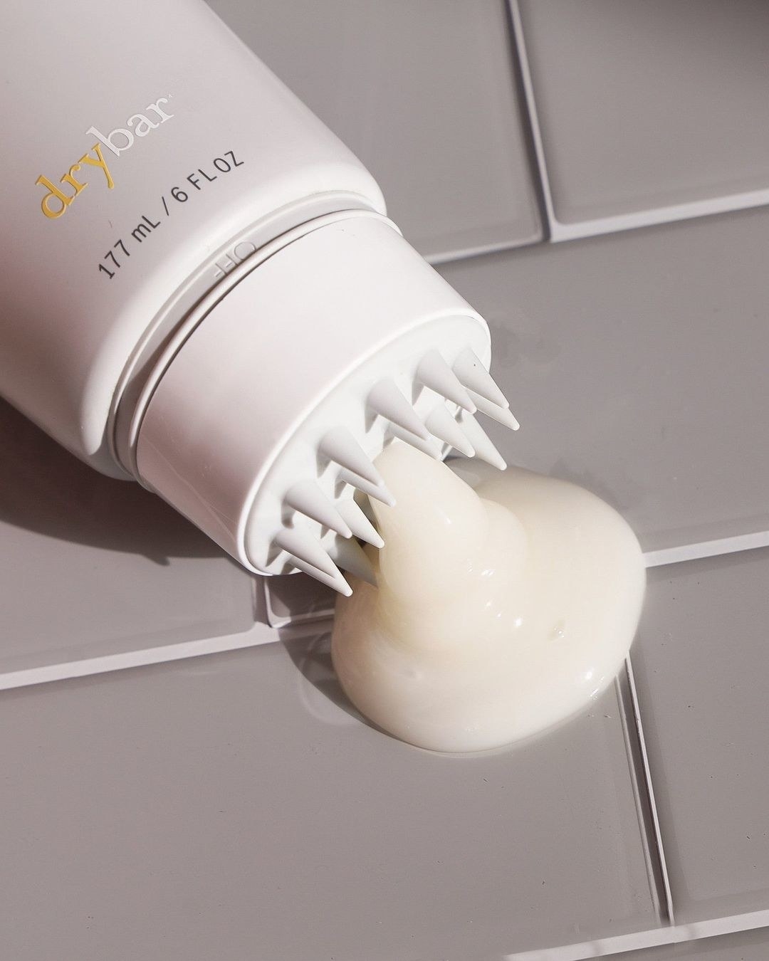 a close up of the scalp cleanser oozing out of the massaging applicator