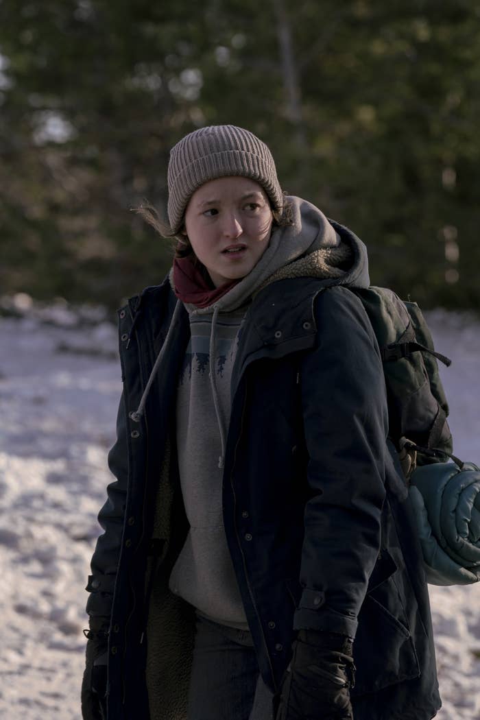 Ellie walking through the snow wearing winter clothing, including a beanie, a a hoodie, and gloves