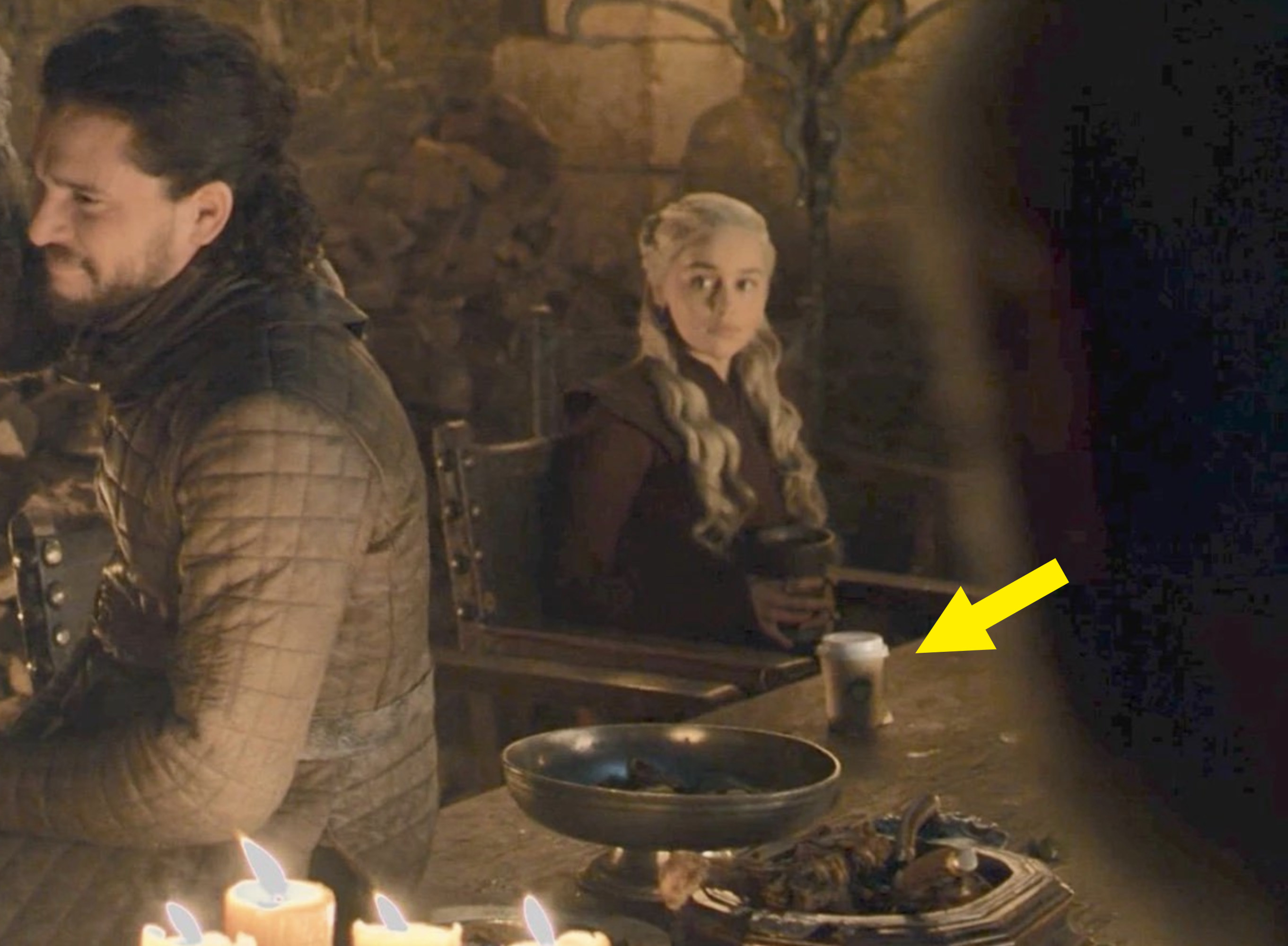 An arrow pointing to the starbucks cup that&#x27;s on a table in front of Daenyrys