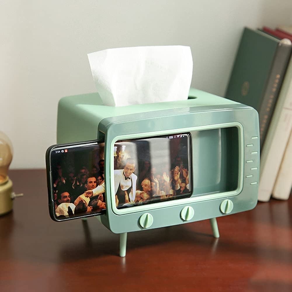 the tissue box on a table holding a phone and tissues