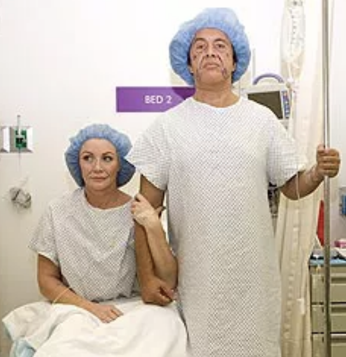 Shannon and Gene in hospital gowns and embracing