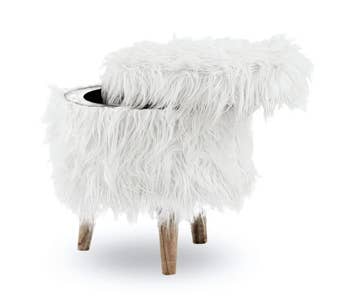 The super shaggy white faux fur storage ottoman with the lid slightly off