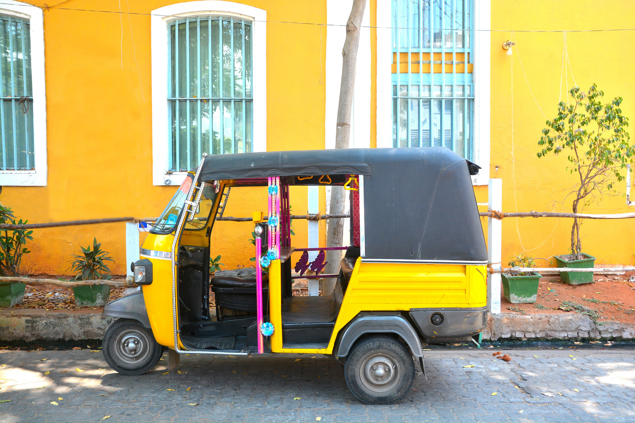 A car parked outside a yellow building.