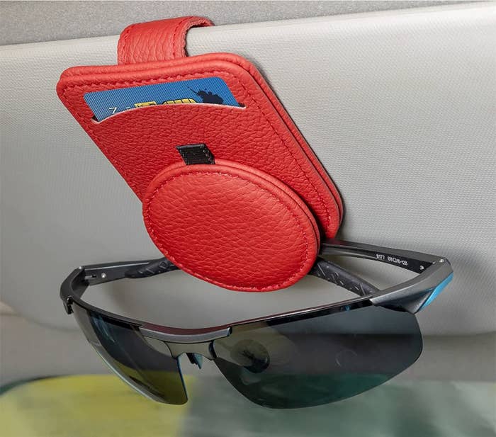 the visor pouch clipped onto a car visor and holding a pair of sunglasses