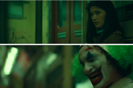 A woman stares at a man in clown makeup on a train
