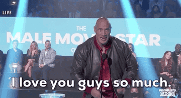 a gif of The Rock lifting an award and saying &quot;I love you guys so much&quot;