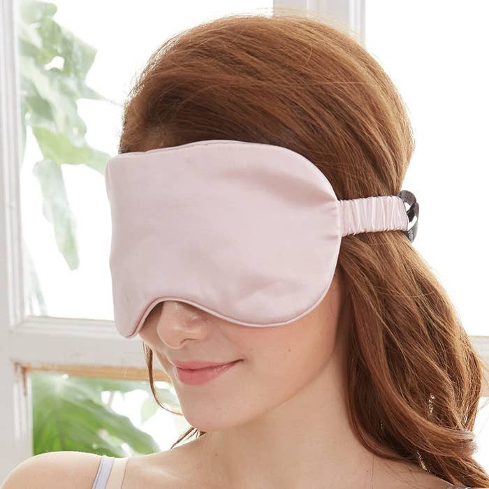 a person with a silk sleep mask over their eyes