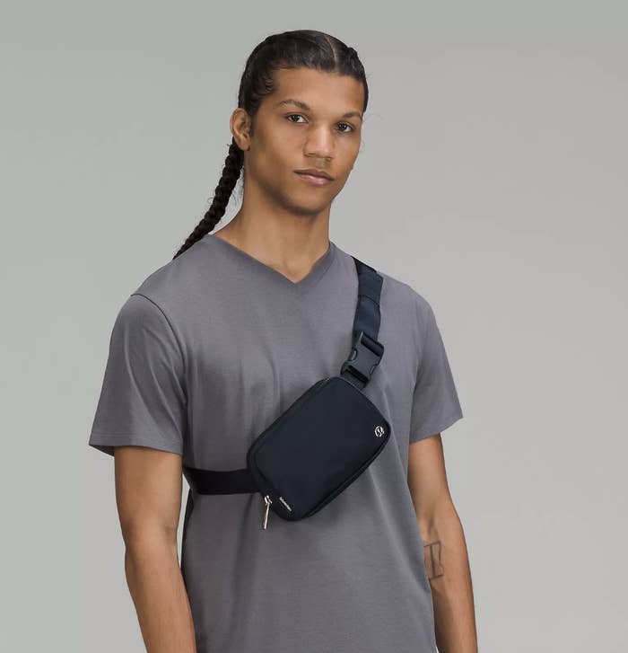 a model wearing the belt bag over a t-shirt in front of a plain background