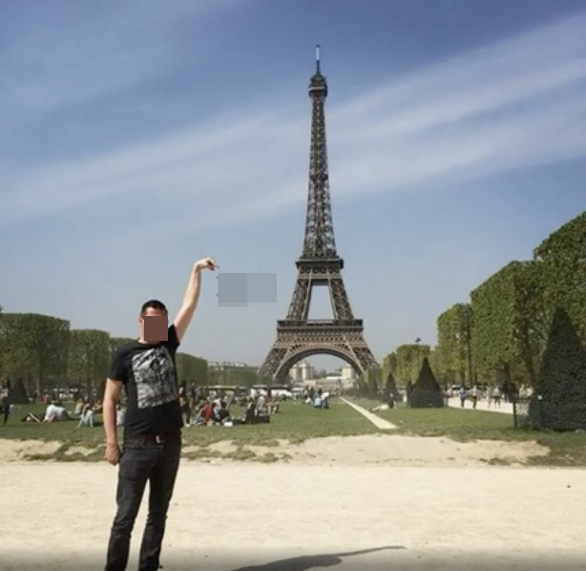 A man posing in front of the Eiffel Tower