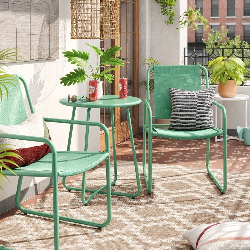 A green outdoor patio set is shown