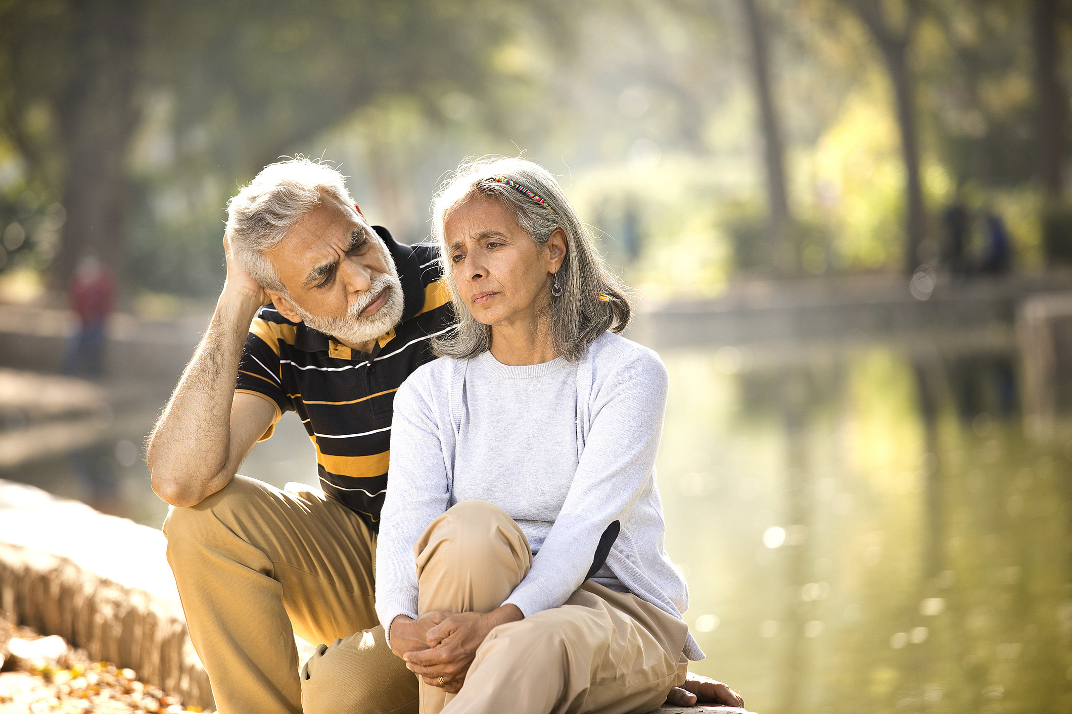 Unhappy man and woman sitting by the water
