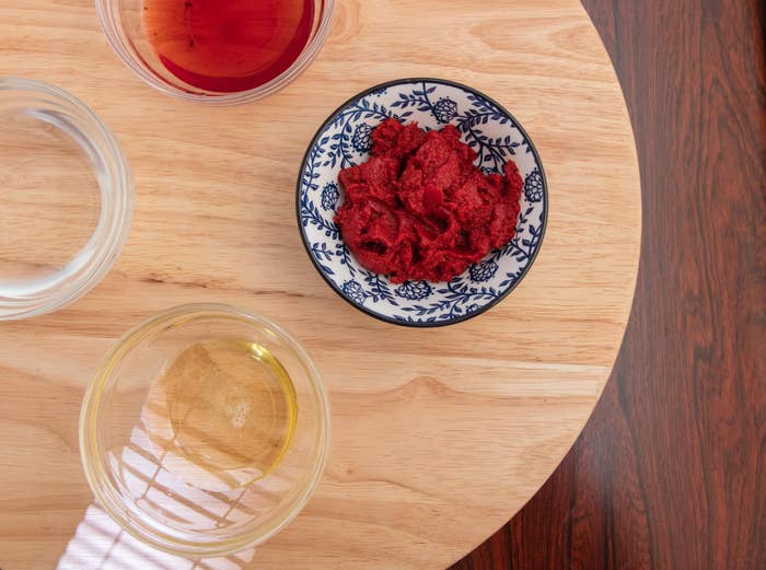 A bowl of tomato paste on a table.