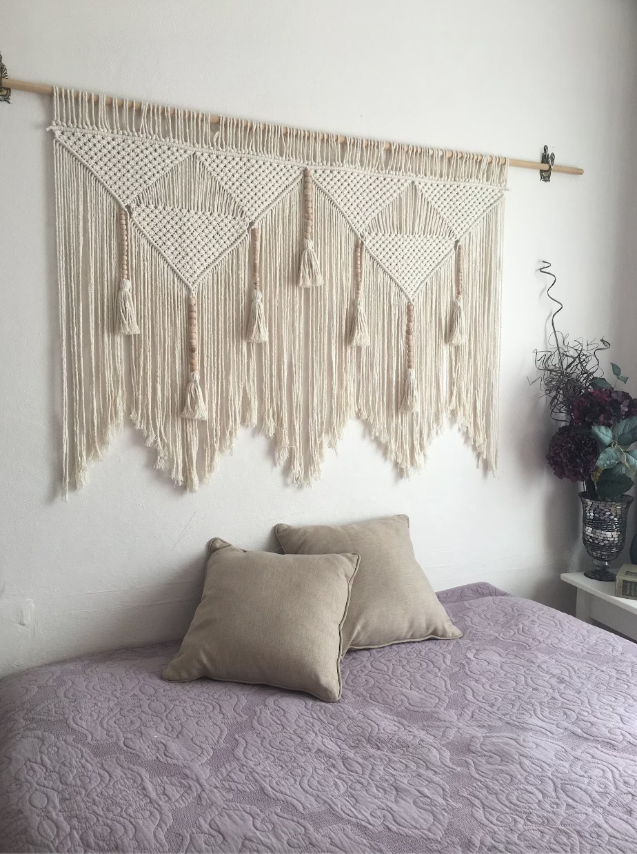 Macrame tapestry on wall behind bed