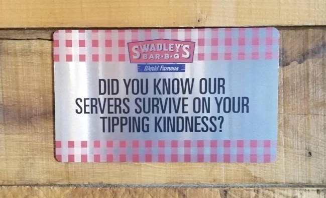 A sign stating that servers are not paid enough to survive and depend on customers&#x27; tips