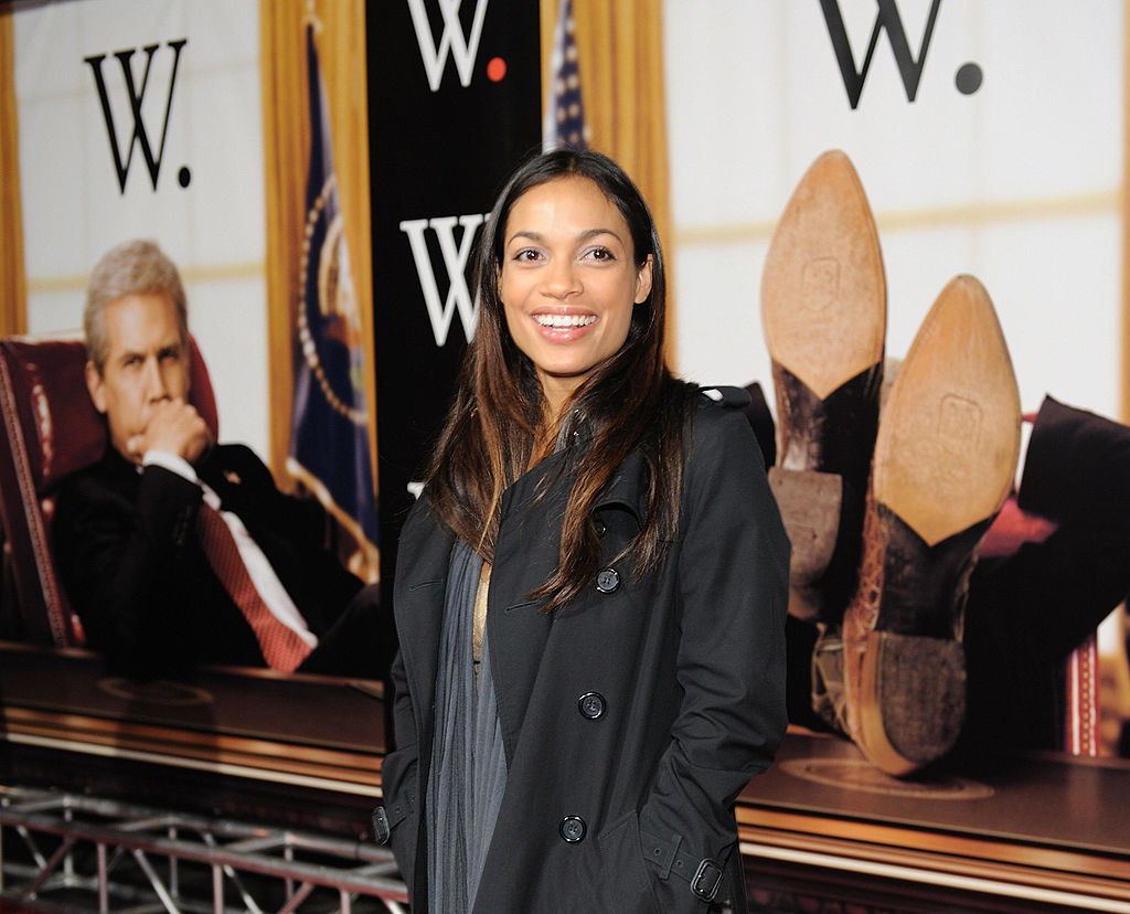 rosario dawson smiling in front of w. posters