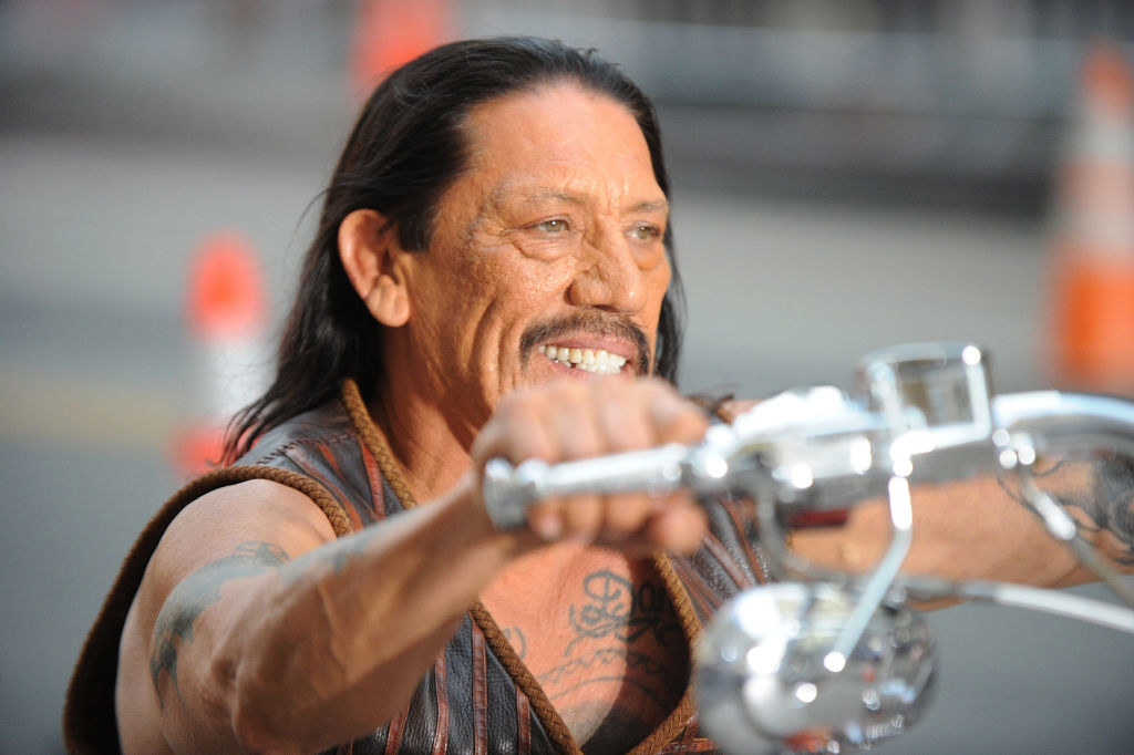 a close up of danny trejo on a motorcycle smiling