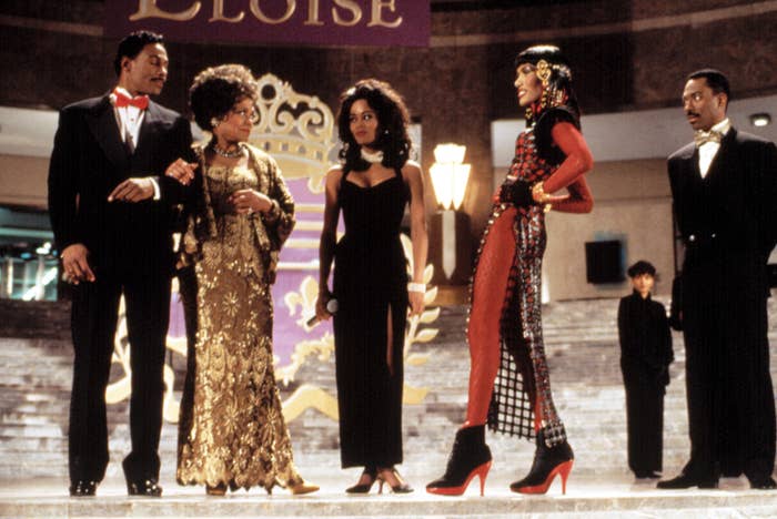 Black women and men stand on a stage in formal wear