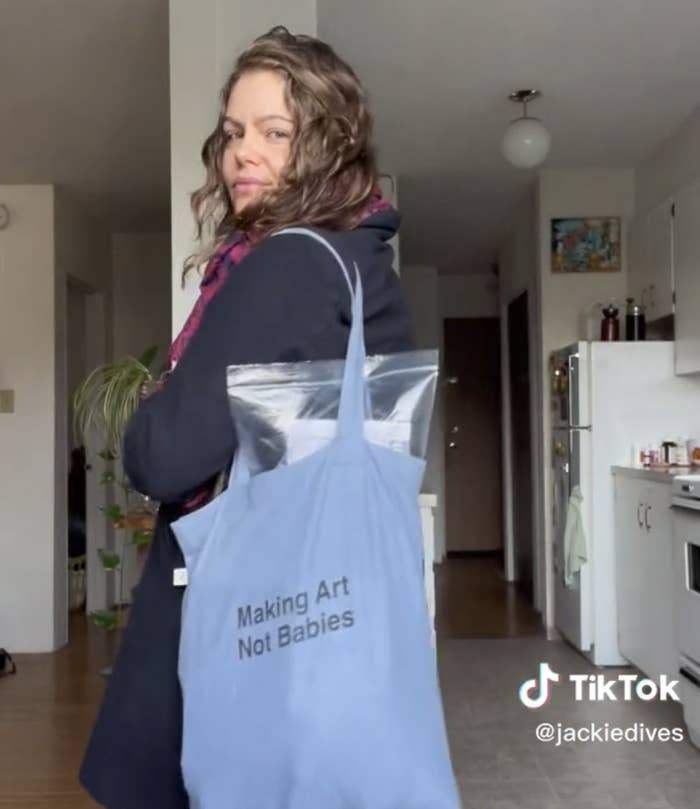 Jackie showing off her tote bag that says &quot;Making Art Not Babies&quot;