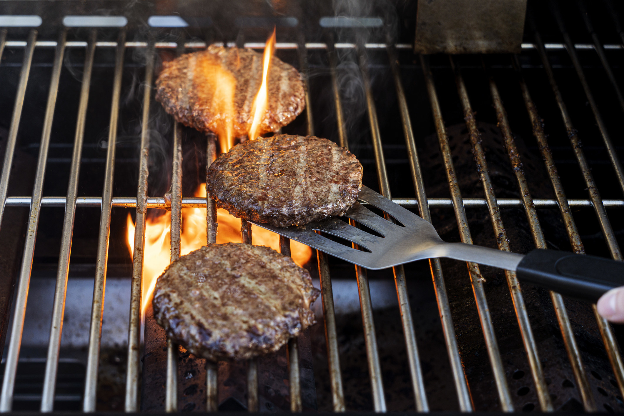 Burgers cook on grill