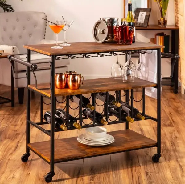 The bar cart with wine bottles, glasses, and cups on it.