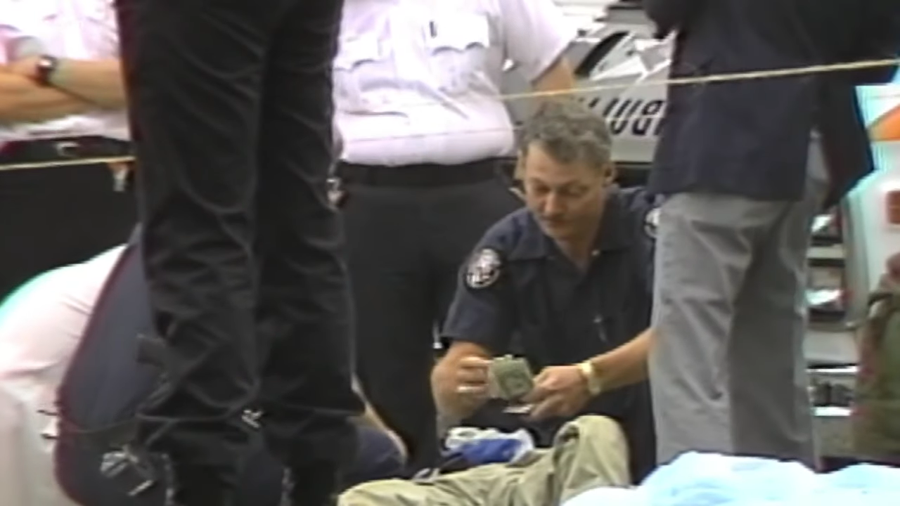 A police officer crouching down and counting dollar bills