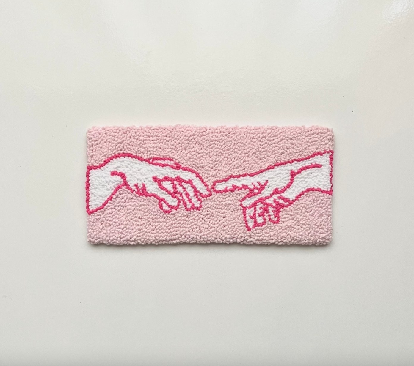 Pink tufted depiction of The Creation of Adam