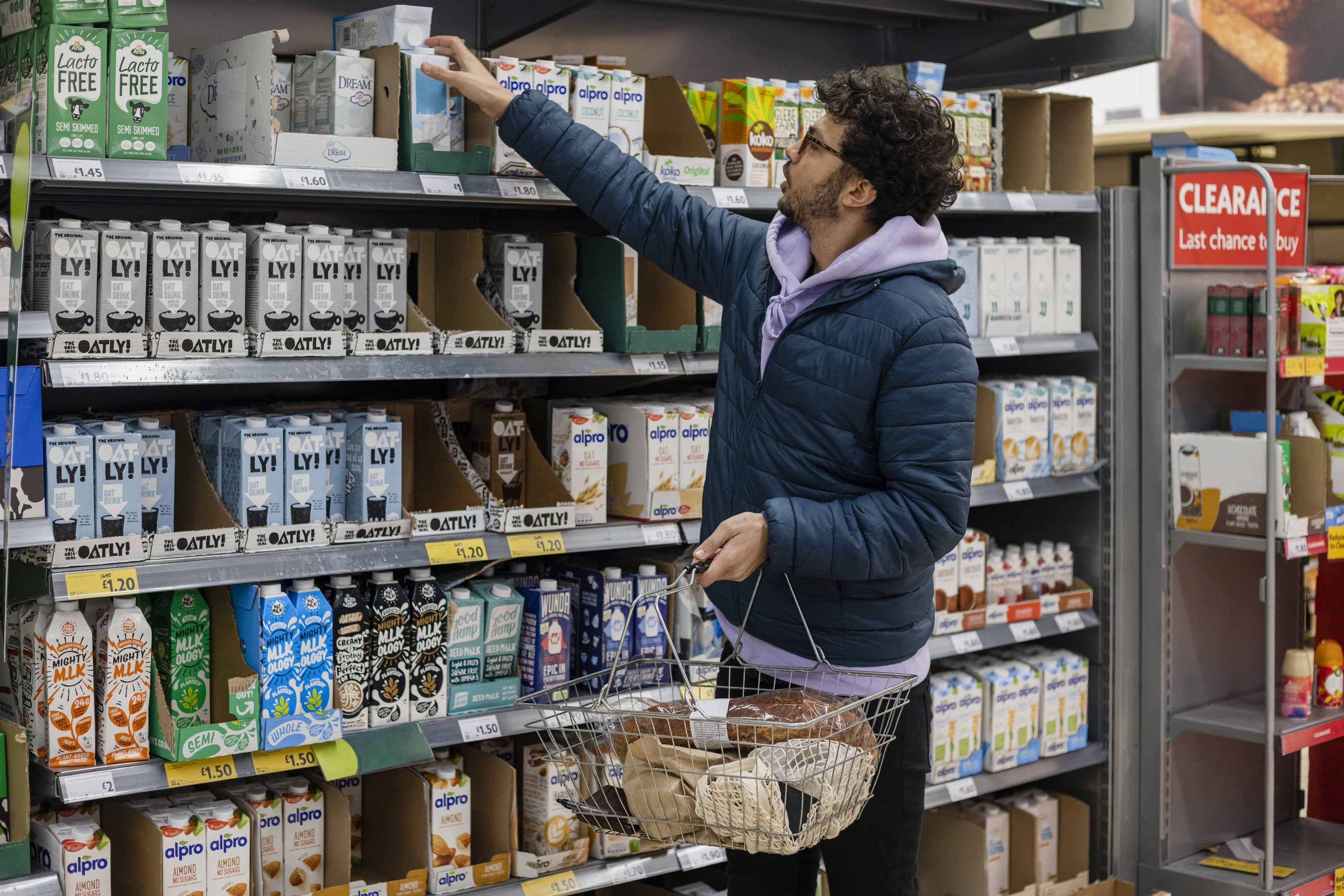 man reaches for milk in nondairy milk aisle