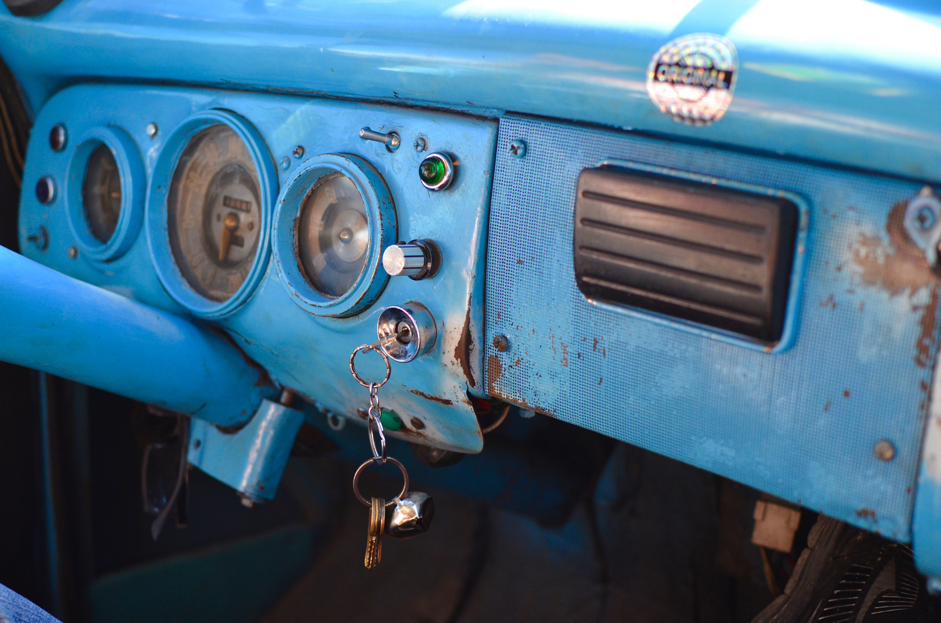 The interior dashboard area of a vintage 1950s car in Cuba featuring jerry-rigged non-original equipment