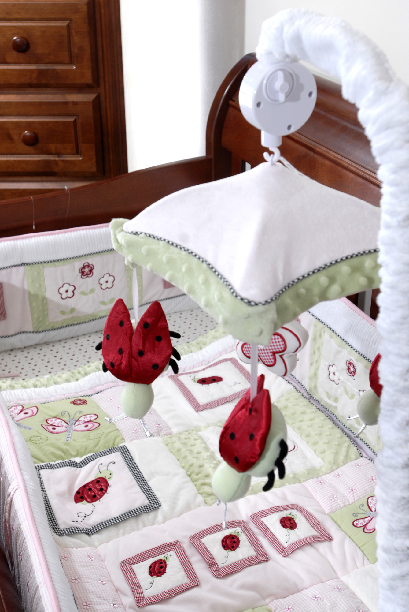 A mobile by &quot;Kids Line&quot; completes the lady bug motif in the bedding