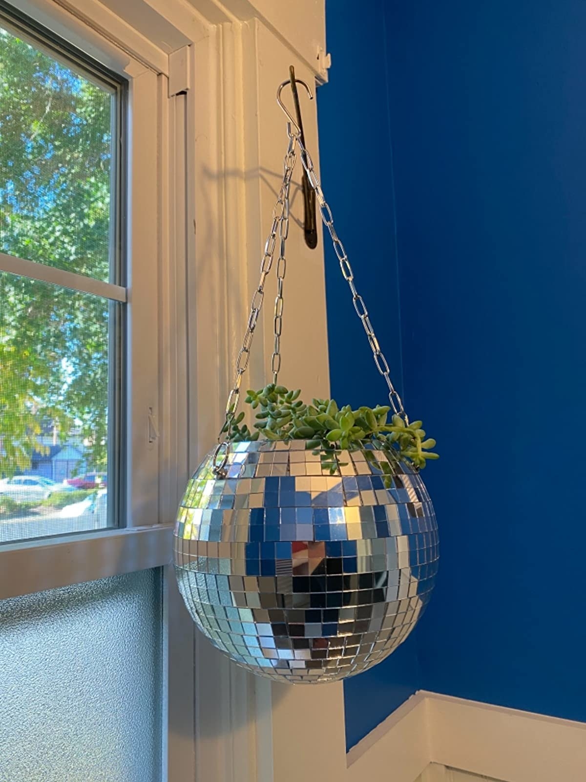 Hanging silver disco ball planter with plant inside
