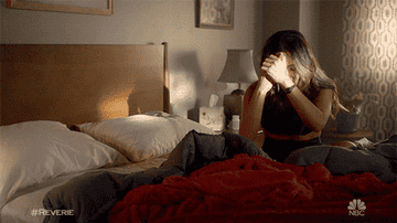 Woman crying while sitting in bed