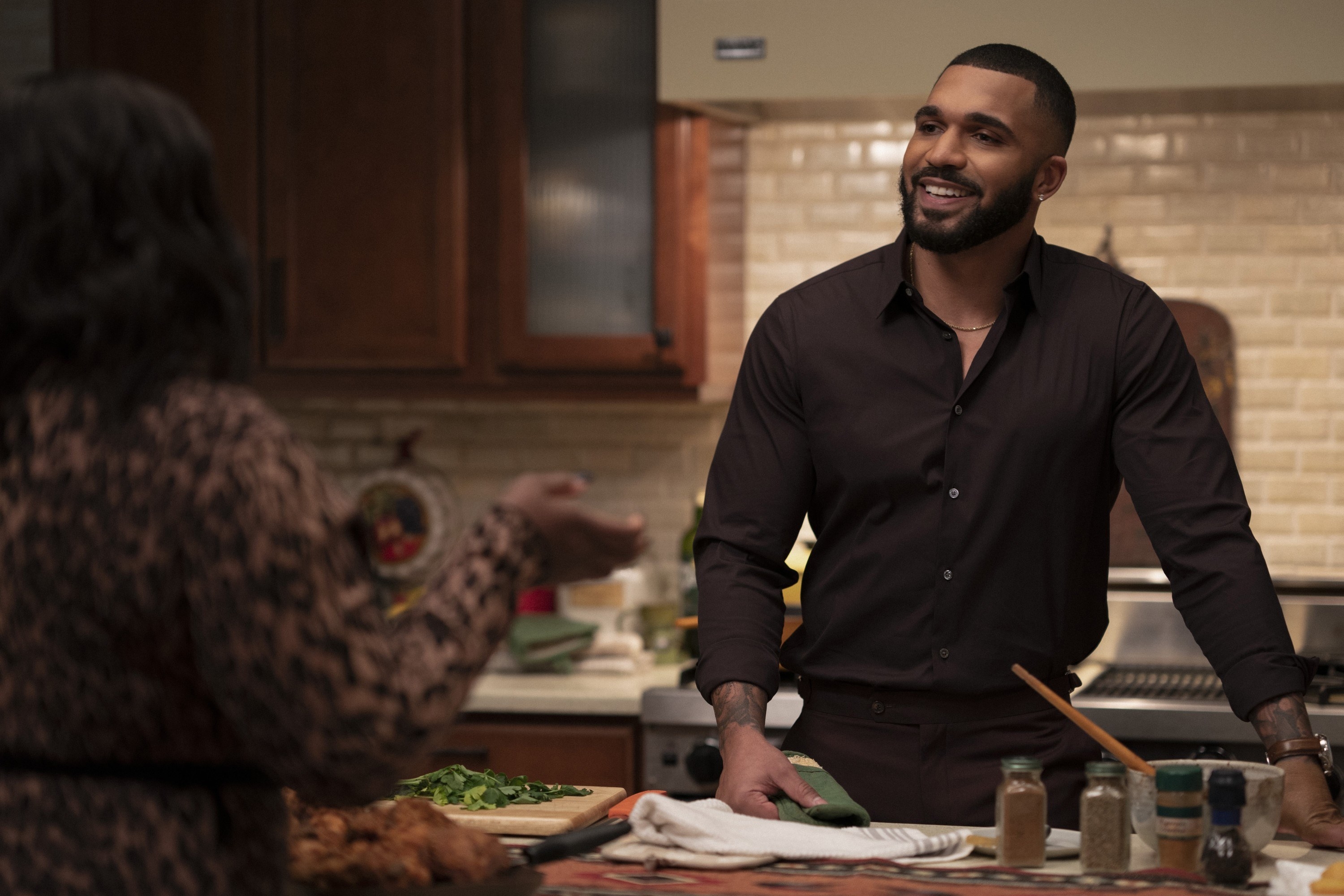 Tyler Lepley leaning on the kitchen island on &quot;Harlem&quot;