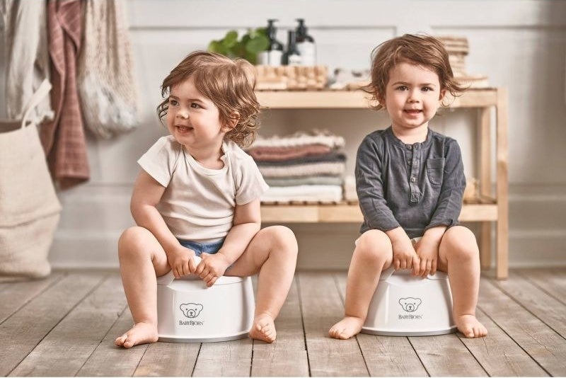 Two children sit on potties