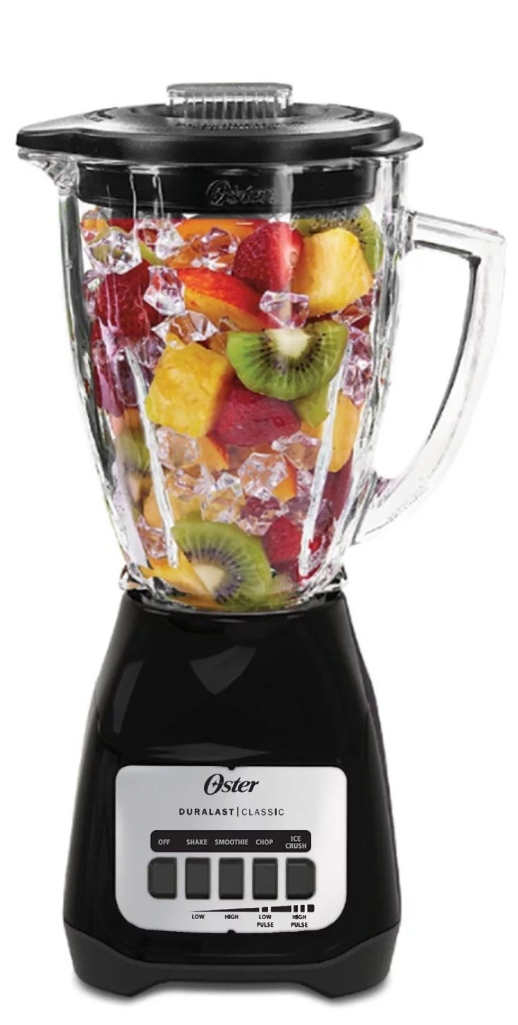 a black blender with a glass jar holding ice and fruit