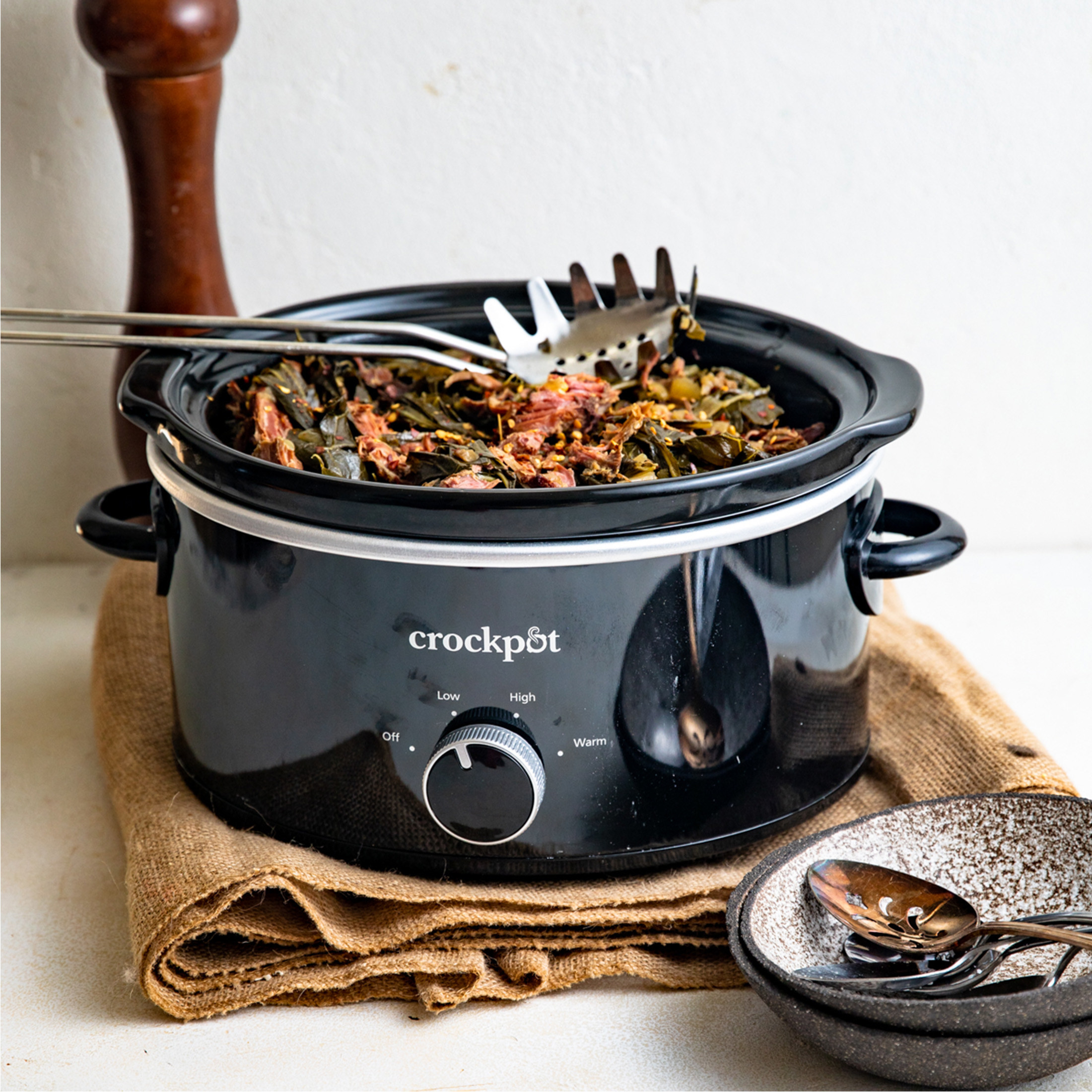 a black Crock-Pot slow cooker containing cooked vegetables