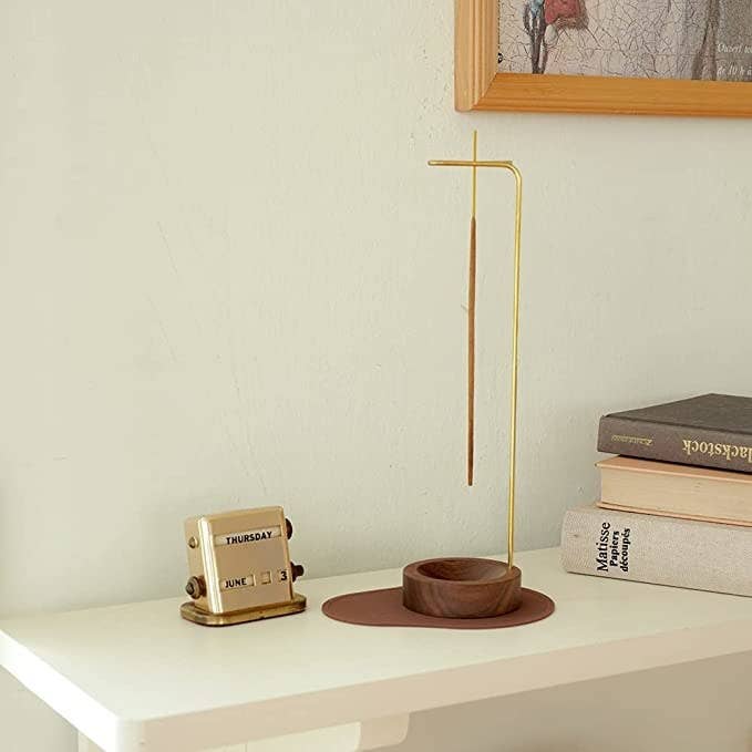a reviewer photo of the incense holder next to books