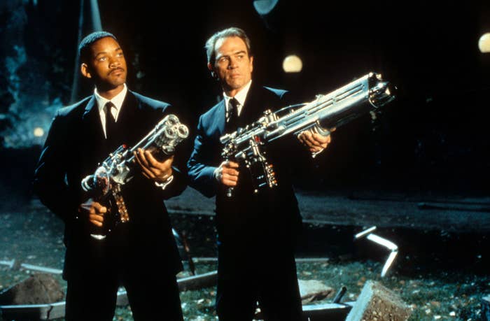 Will Smith and Tommy Lee Jones aiming their weapons towards the sky in a scene from the film &#x27;Men In Black&#x27;, 1997