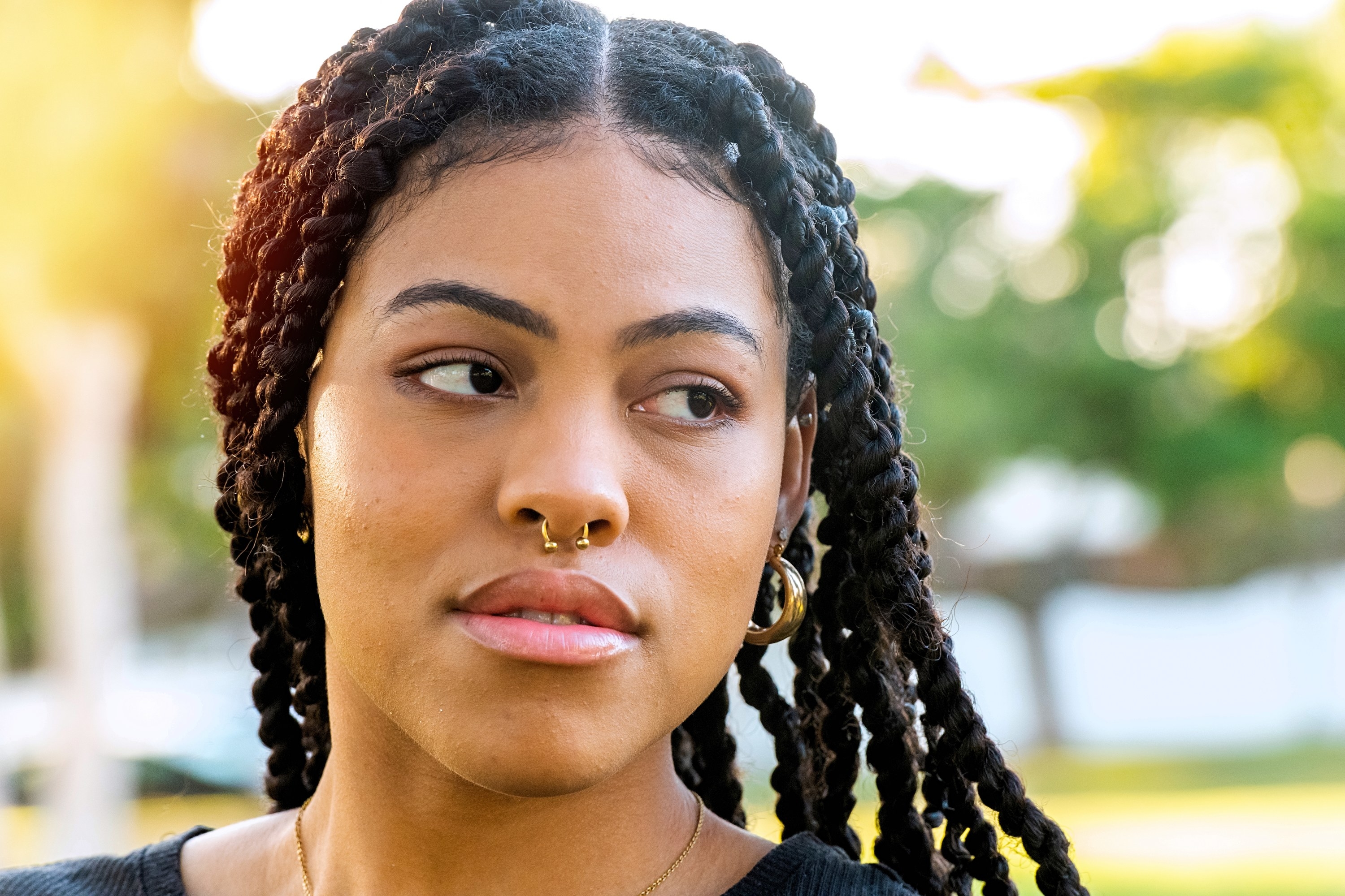 afrolatine woman with braids and a septum piercing