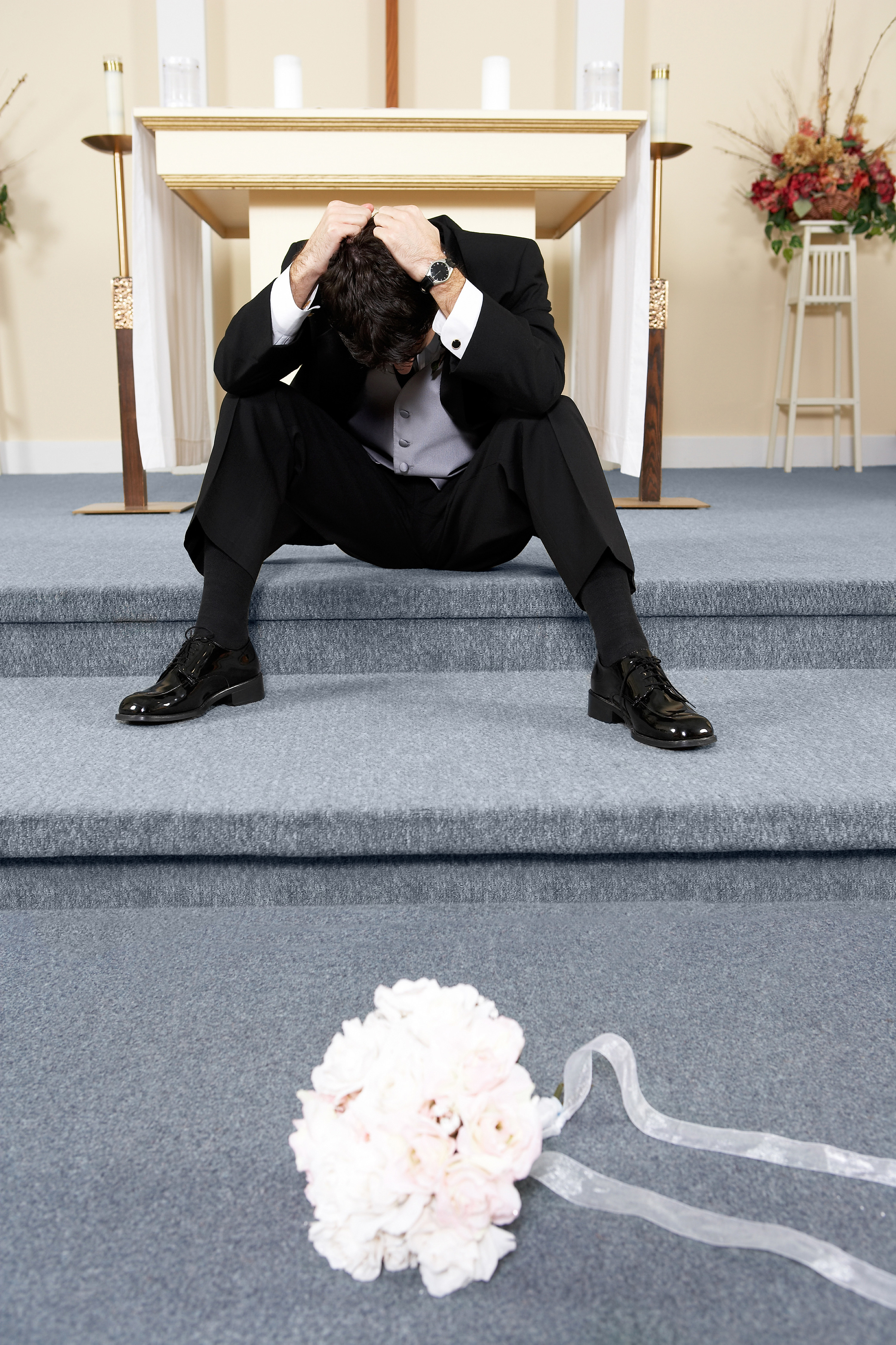 groom crying with bridal bouquet on ground