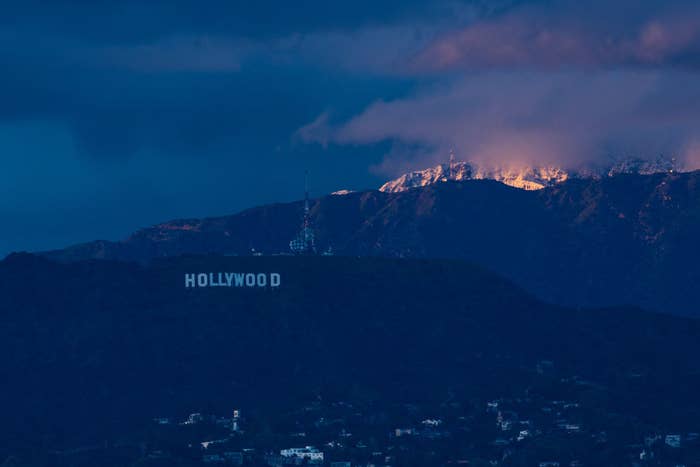 A view of the downtown Los Angeles skyline with the snow-covered San Gabriel Mountains in the background seen from Kenneth Hahn Park as a winter storm sweeps through California