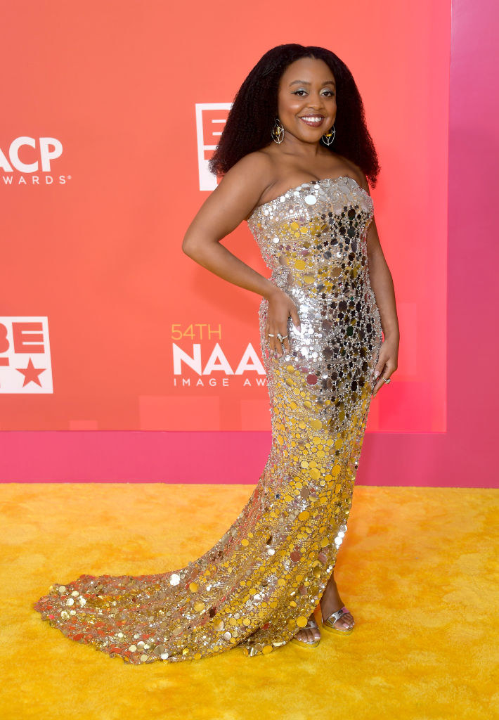 Quinta on the red carpet in a strapless sequined gown with train