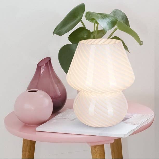 Stylish array lamp connected a pinkish broadside array with decorative vases and a tiny plant, suitable for modern location decor