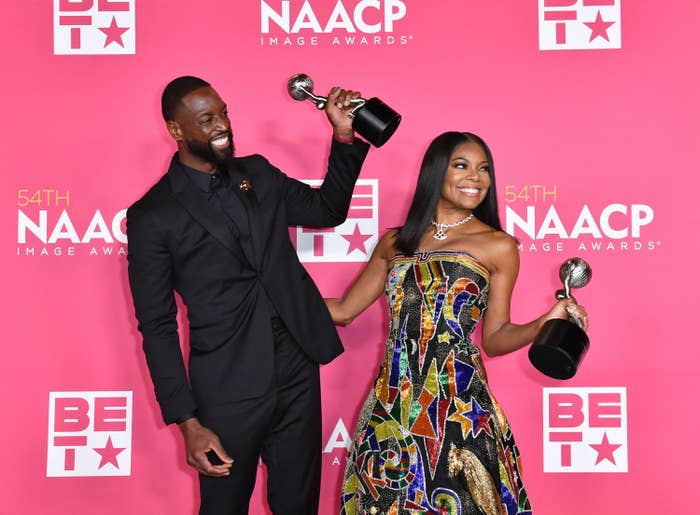 Dwyane and Gabrielle holding their awards on the red carpet