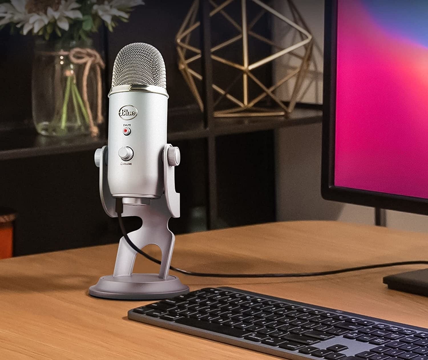 a blue yeti microphone on a desk with a keyboard and computer