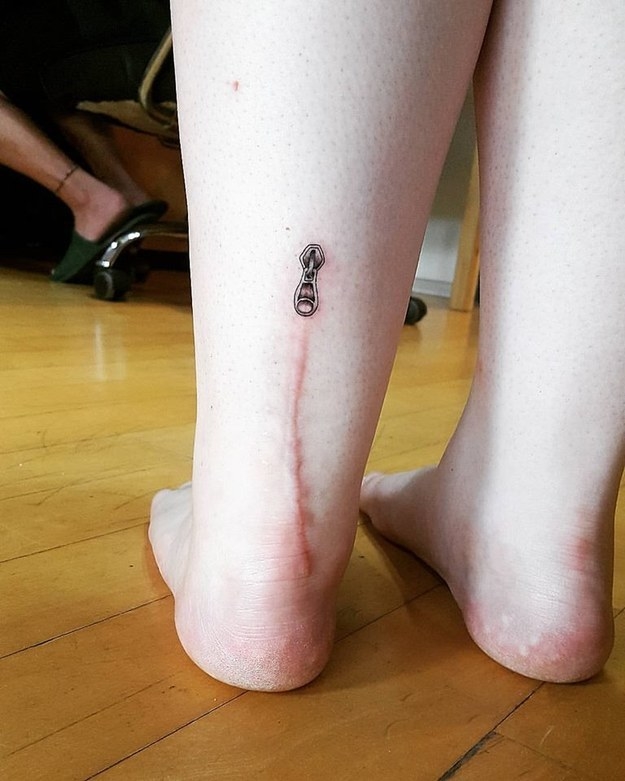 Zipper tattoo at the top of a surgery scar on the back of someone&#x27;s leg