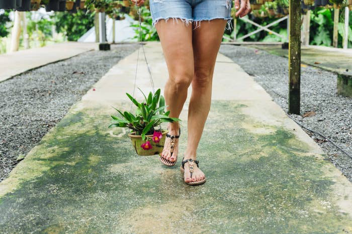 A woman wearing shorts and walking along a sidewalk